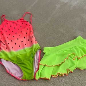 A water melon swimsuit. It is pink and there is a neon skirt that goes over it.